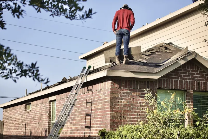 Professional roofer working on a residential roof in Miamiville